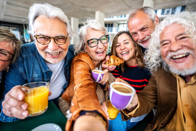 Happy senior people taking selfie picture sitting at cafe bar table - Older friends having breakfast together drinking coffee and fruit juice outdoors - Food and beverage lifestyle concept Wspólne śniadanie w gronie znajomych przy stole, swobodna i poranna atmosfera